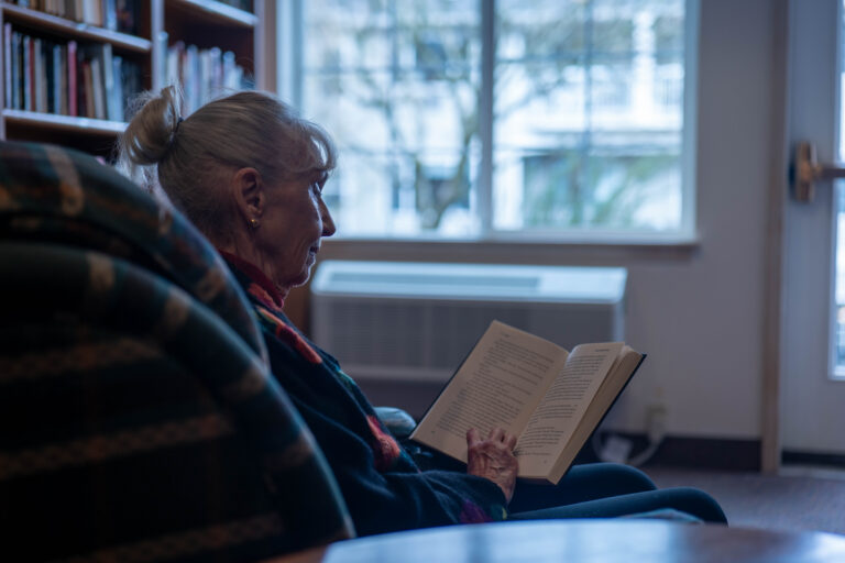 Resident reading by a window in the library