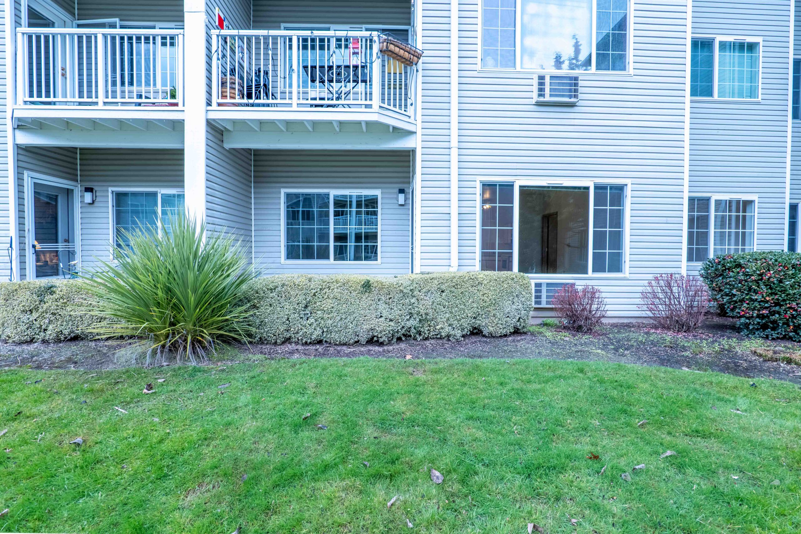 Apartment building exterior with balconies and a lawn